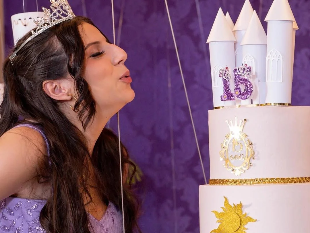 Debutante assoprando as velas do bolo de 15 anos